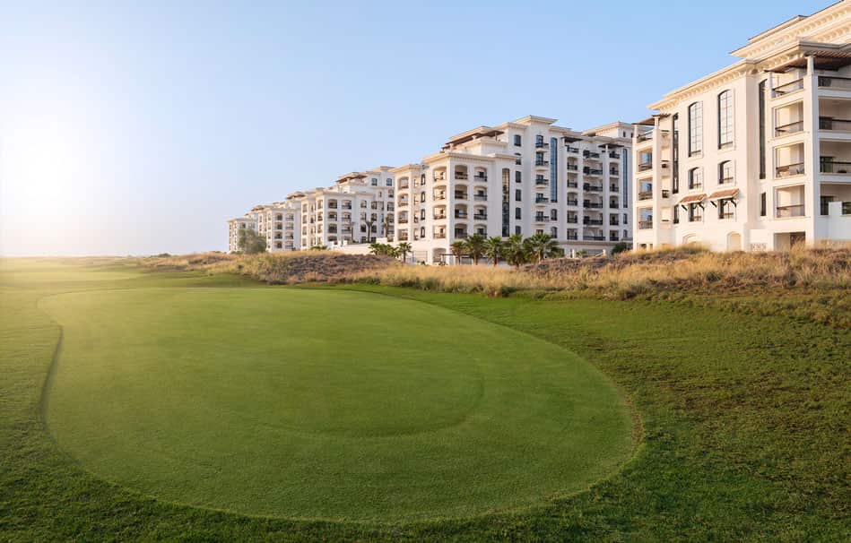 Exterior facade of Ansam Yas Island apartments highlighting Andalusian-style arches, terracotta roofs, and warm Mediterranean design details in Abu Dhabi.